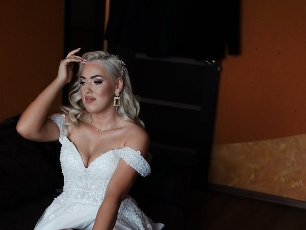 Nuotaka sėdi ruošdamasi vestuvėms, plaukai sugarbanoti – vestuvių fotosesija Šiauliuose