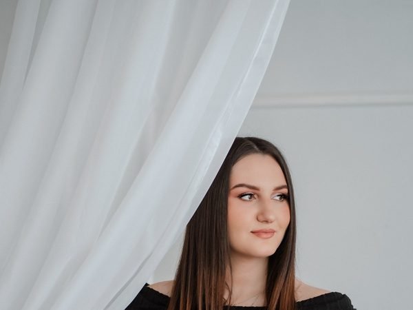 Moteris stovi už permatomos baltos užuolaidos studijoje – laukimo fotosesija Šiauliuose